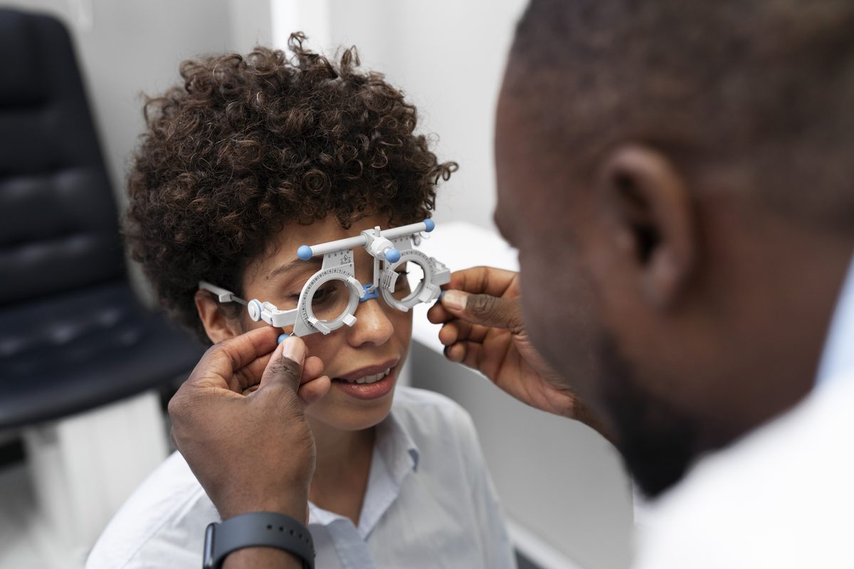 Optometrist fitting a trial frame on a young patient during refraction